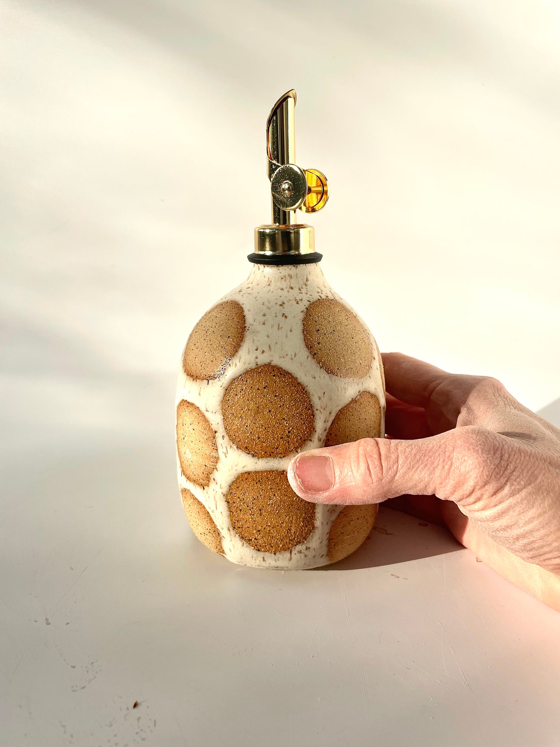 stoneware cruet in speckled clay with large natural clay polka dots showing through - Hey Moon Ceramics