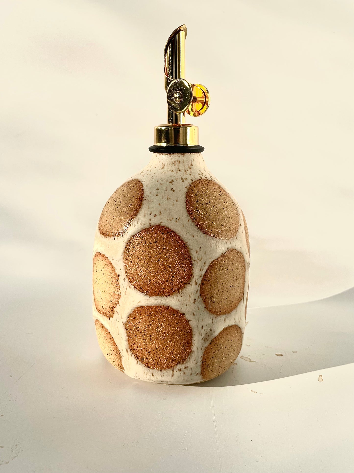 stoneware cruet in speckled clay with large natural clay polka dots showing through - Hey Moon Ceramics