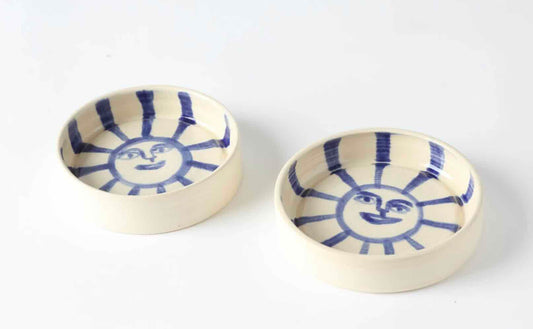 white stoneware catch-all, wheel-thrown by hey moon ceramics. Hand painted with a blue sun face on the interior.