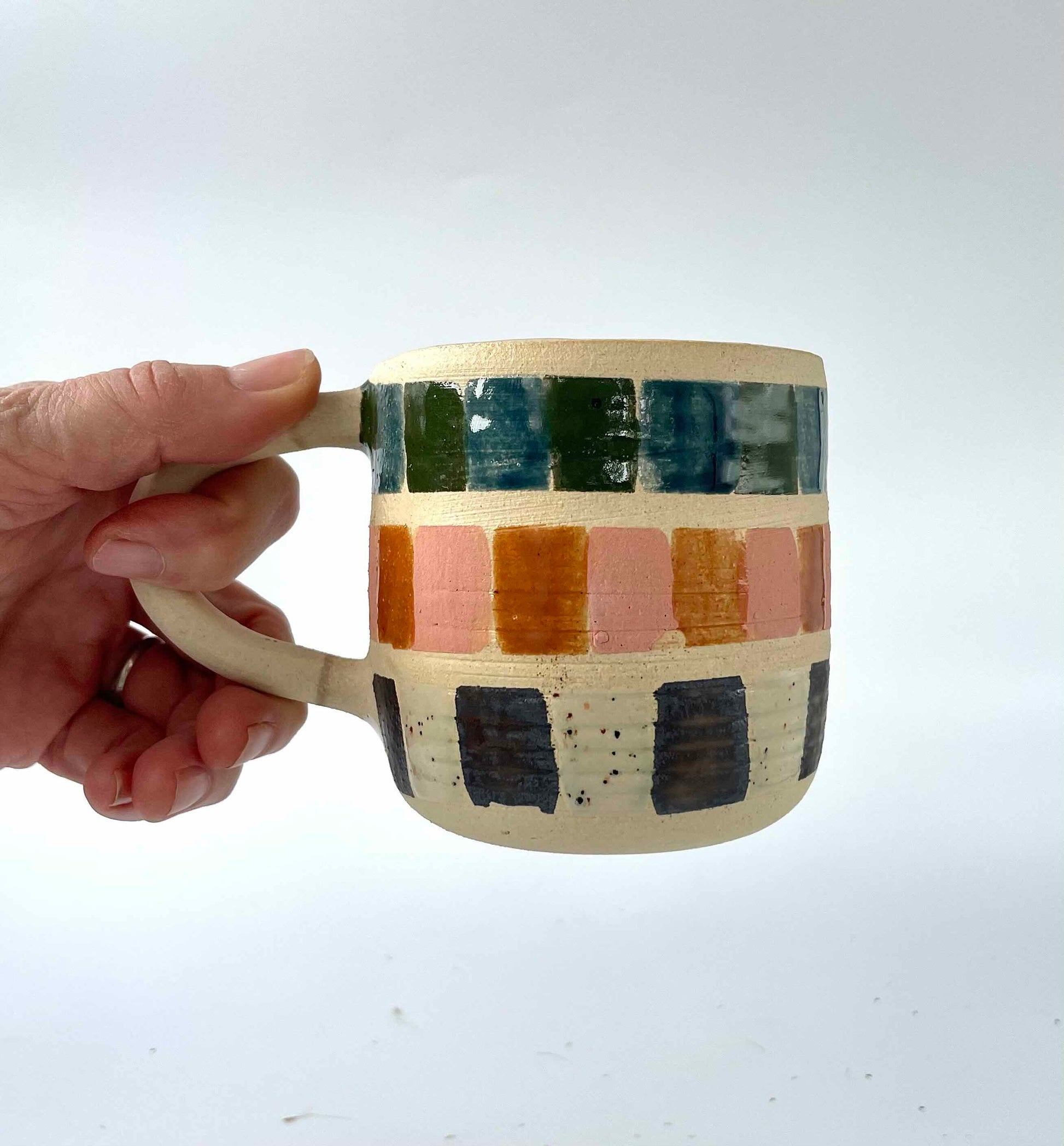 white stoneware mug handpainted in multicolor by hey moon ceramics