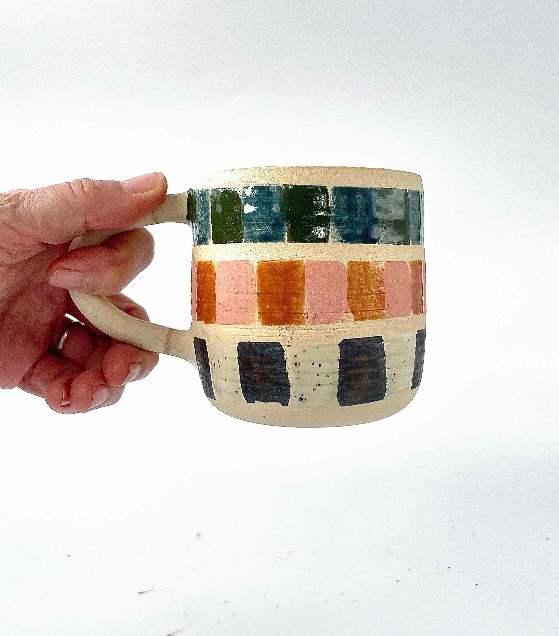 white stoneware mug wheel thrown by hey moon ceramics. handpainted in multicolor mosaic tile pattern