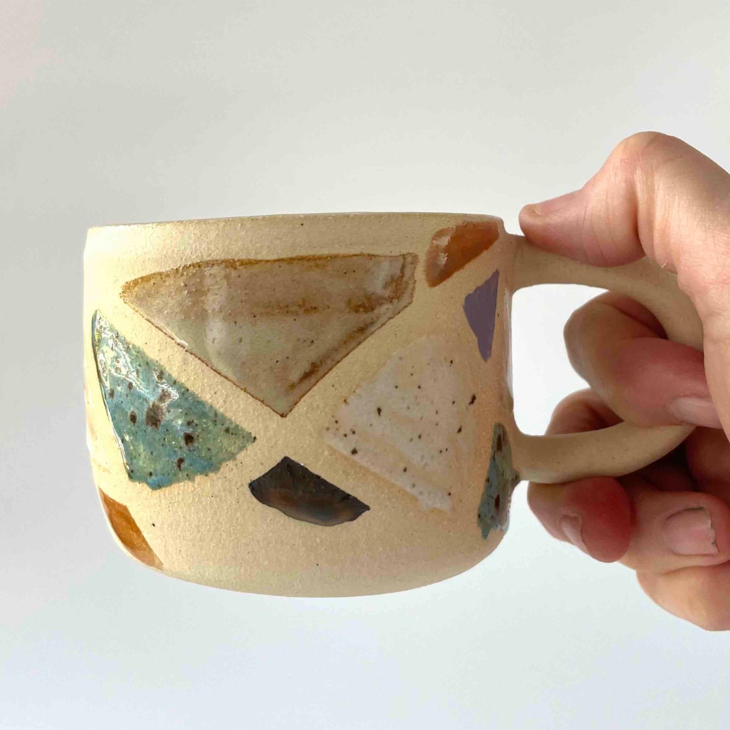 stoneware mug with handpainted multicolor terrazo rock detail by Hey Moon Ceramics